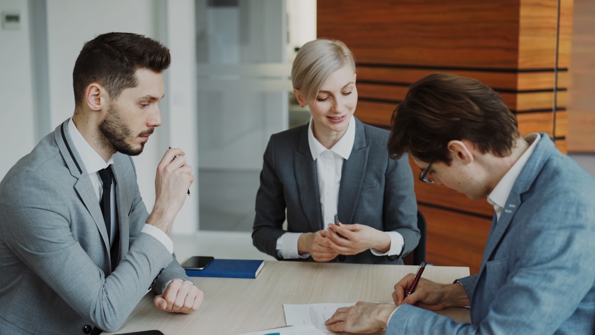 Business people signing a real estate contract at a table