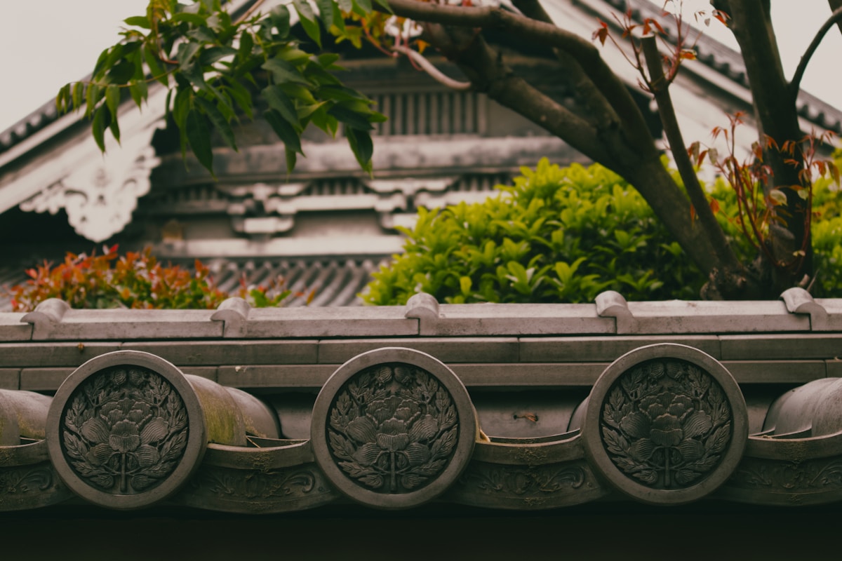 Japanese rooftop with ornate traditional tiles and foliage