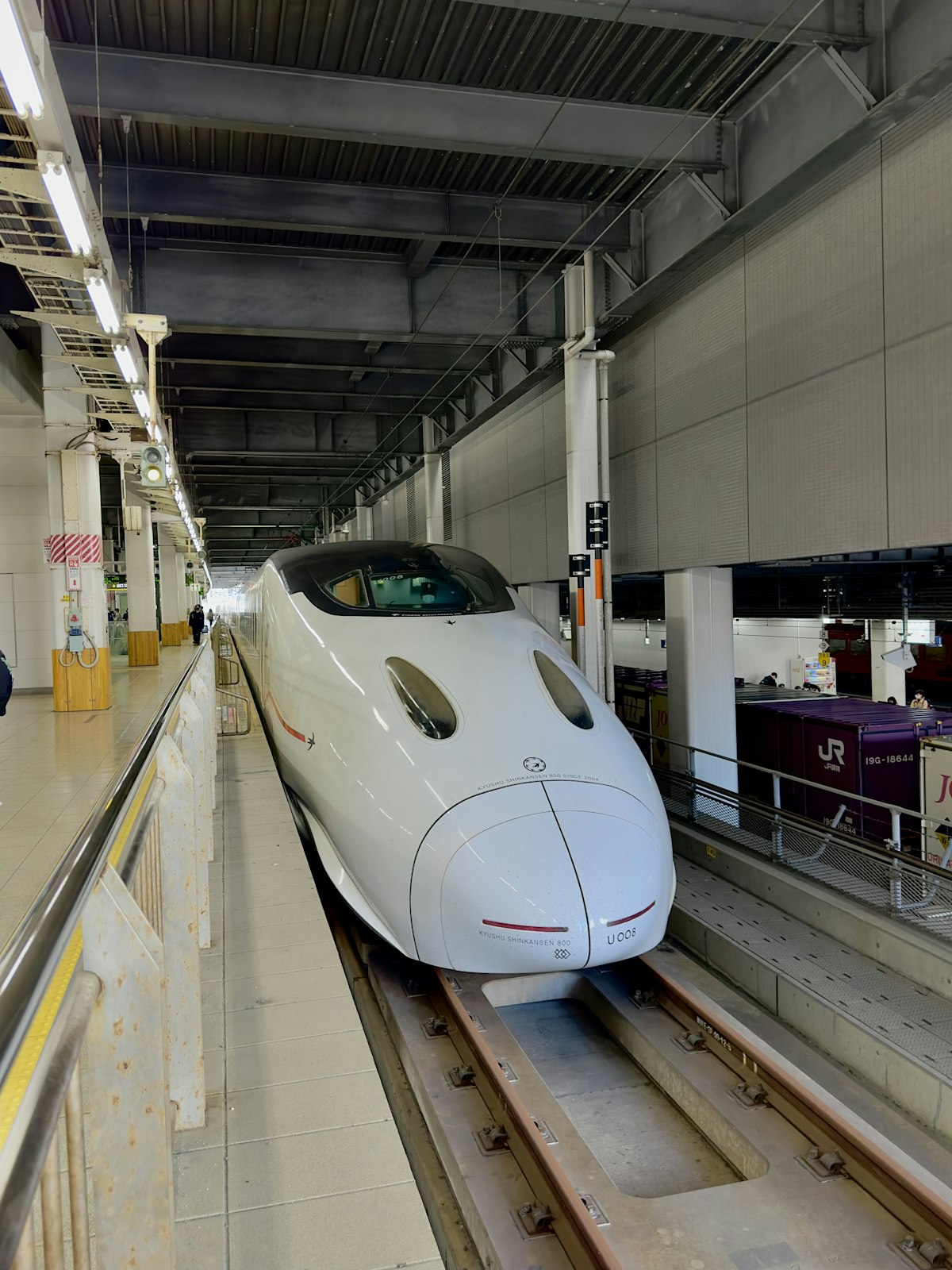 White Shinkansen bullet train at a station platform in Japan
